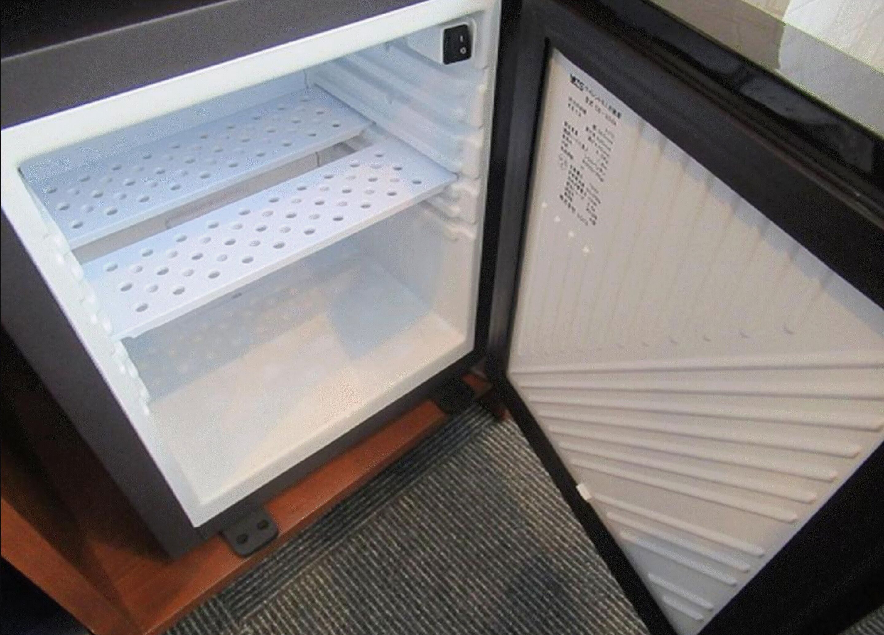 An open refrigerator with two shelves and a control panel on the right.