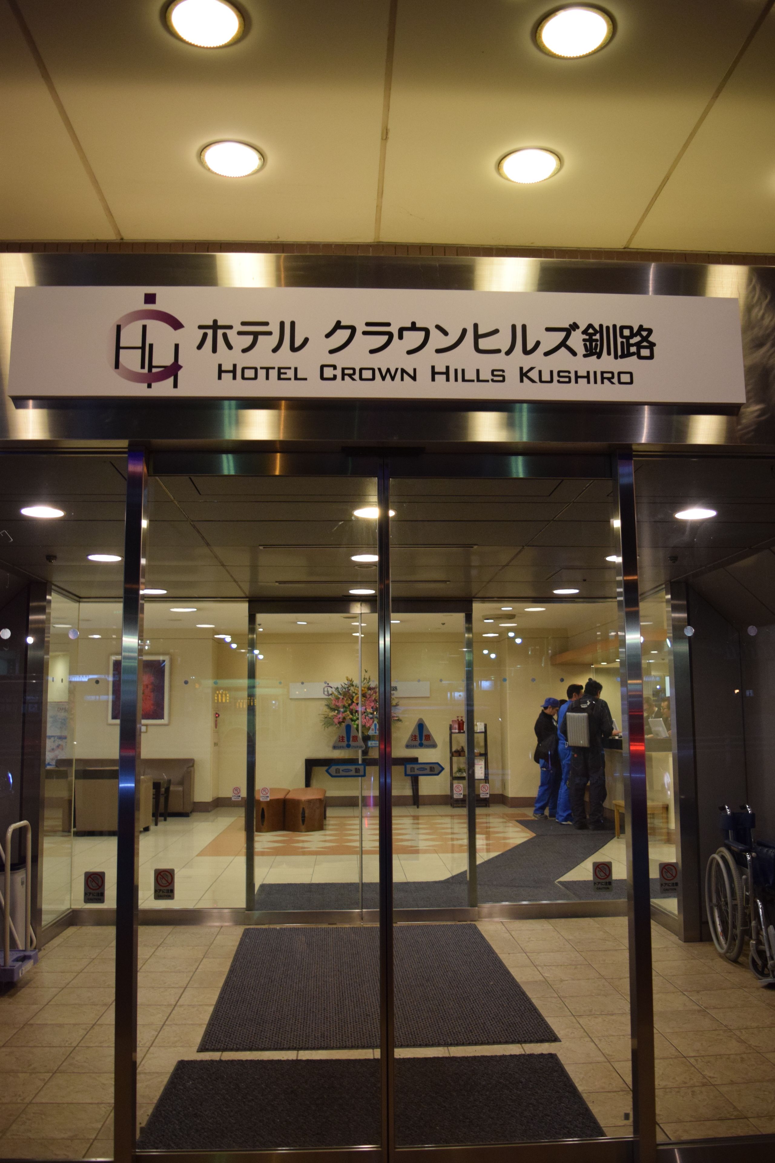 The entrance to Hotel Crown Hills Kushiro with a sign above the doors.