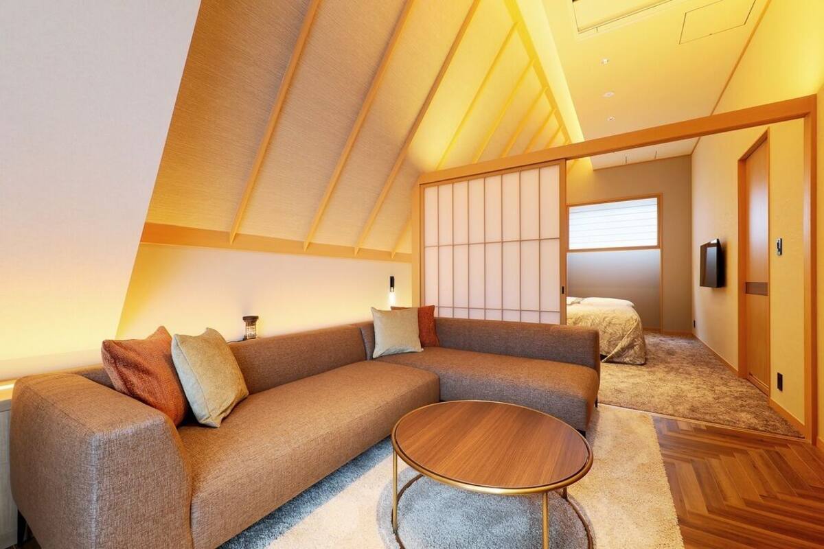 A modern interior with a sectional sofa, a round coffee table, and a sliding shoji screen.