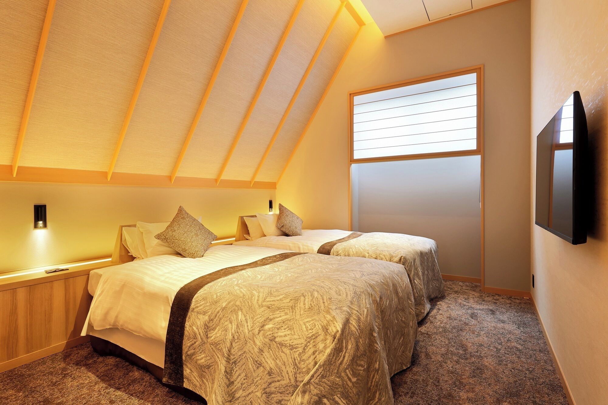 A bedroom with two beds, a window, and a TV.