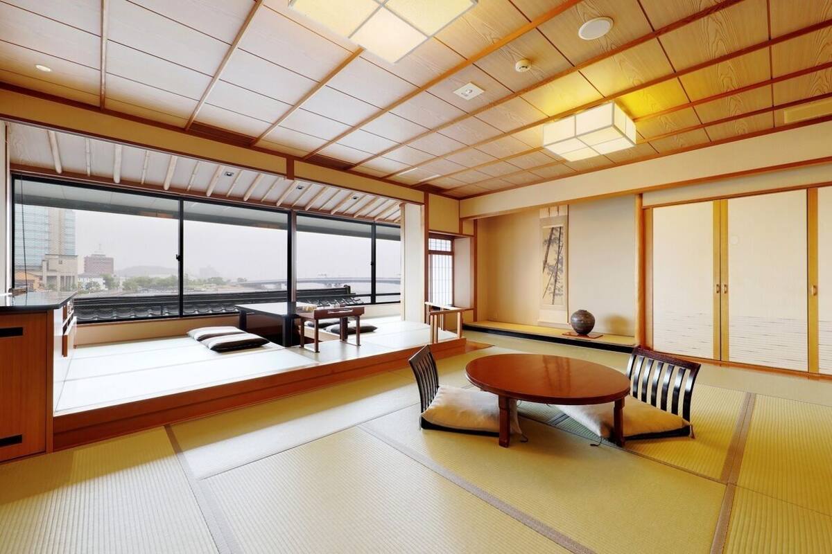 A tatami mat room with a tatami mat table, a low wooden desk, and a sliding door.