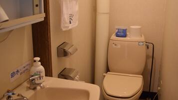 A bathroom with a sink, toilet, and a towel hanging on a rack.