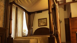 A bedroom with a four-poster bed, a painting on the wall, and a wooden door. - Señorio de Olmillos (Sasamon)