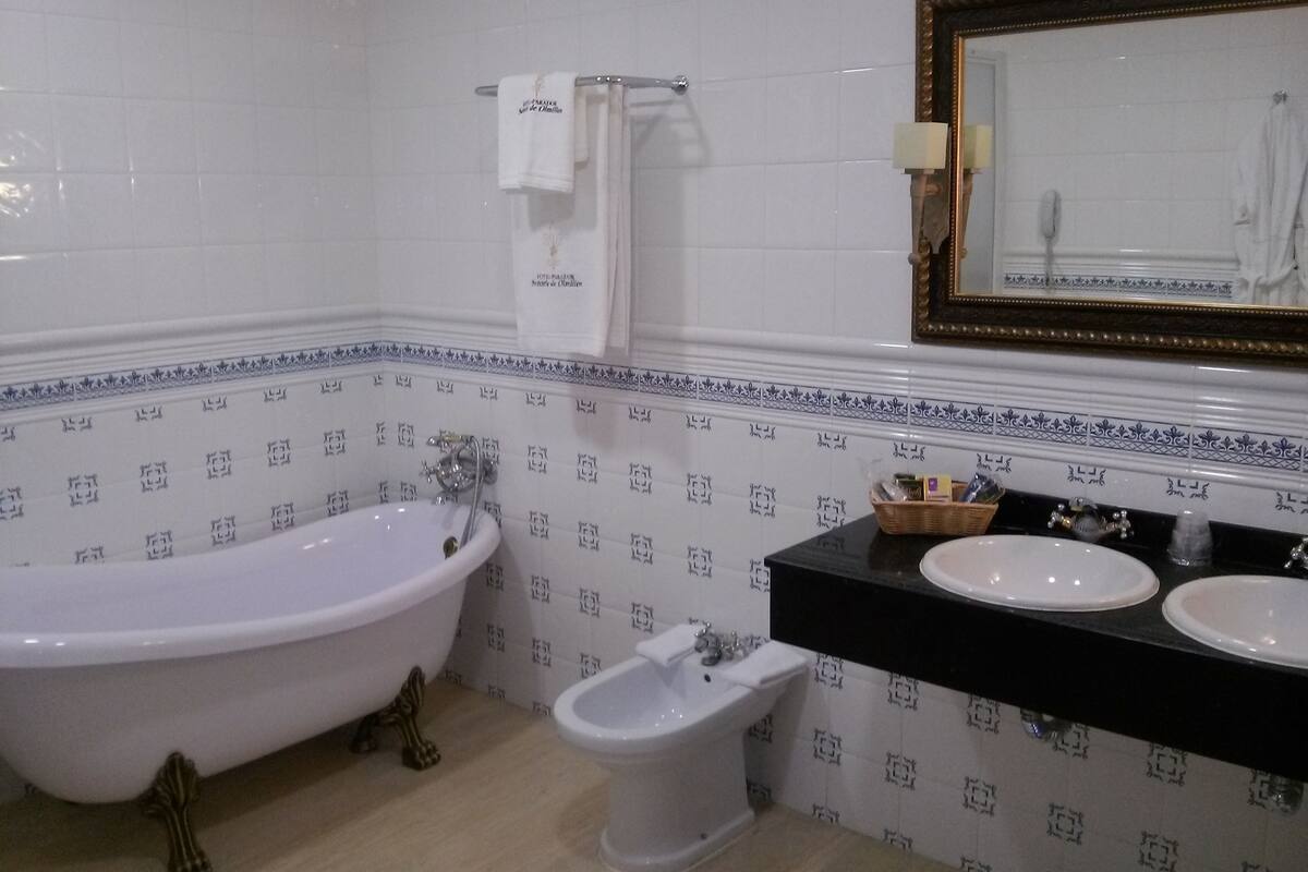A bathroom with a bathtub, a bidet, and a sink with a mirror above.