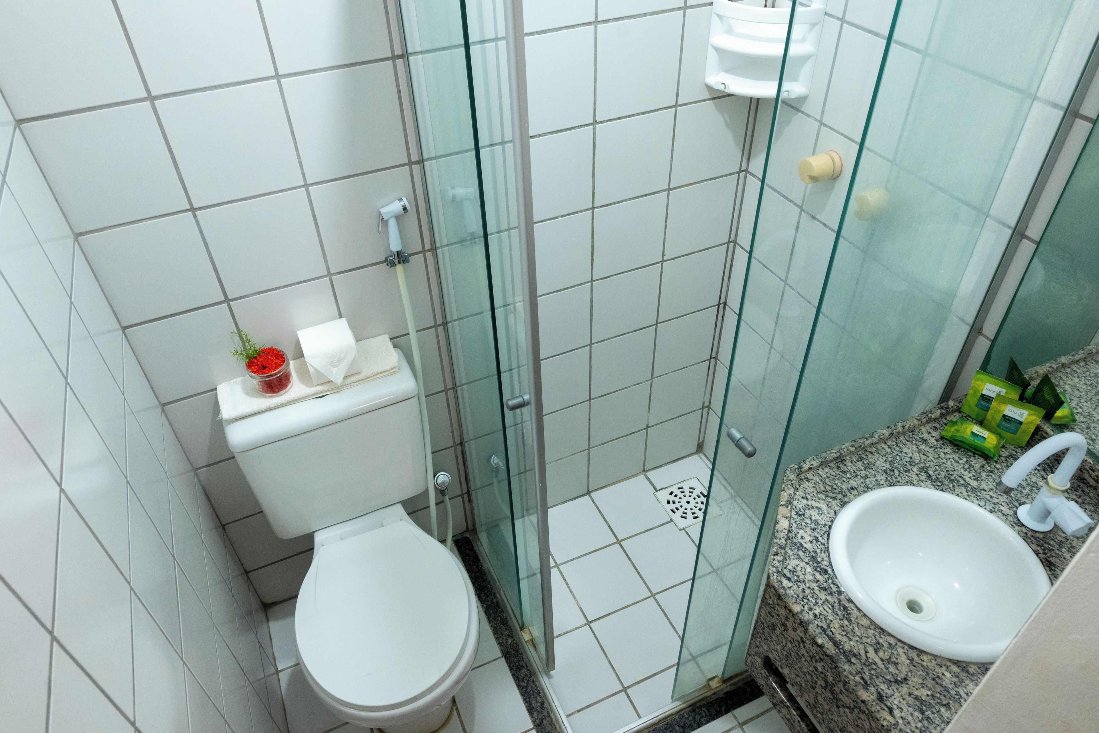 A bathroom with a toilet, a glass shower enclosure, and a sink.