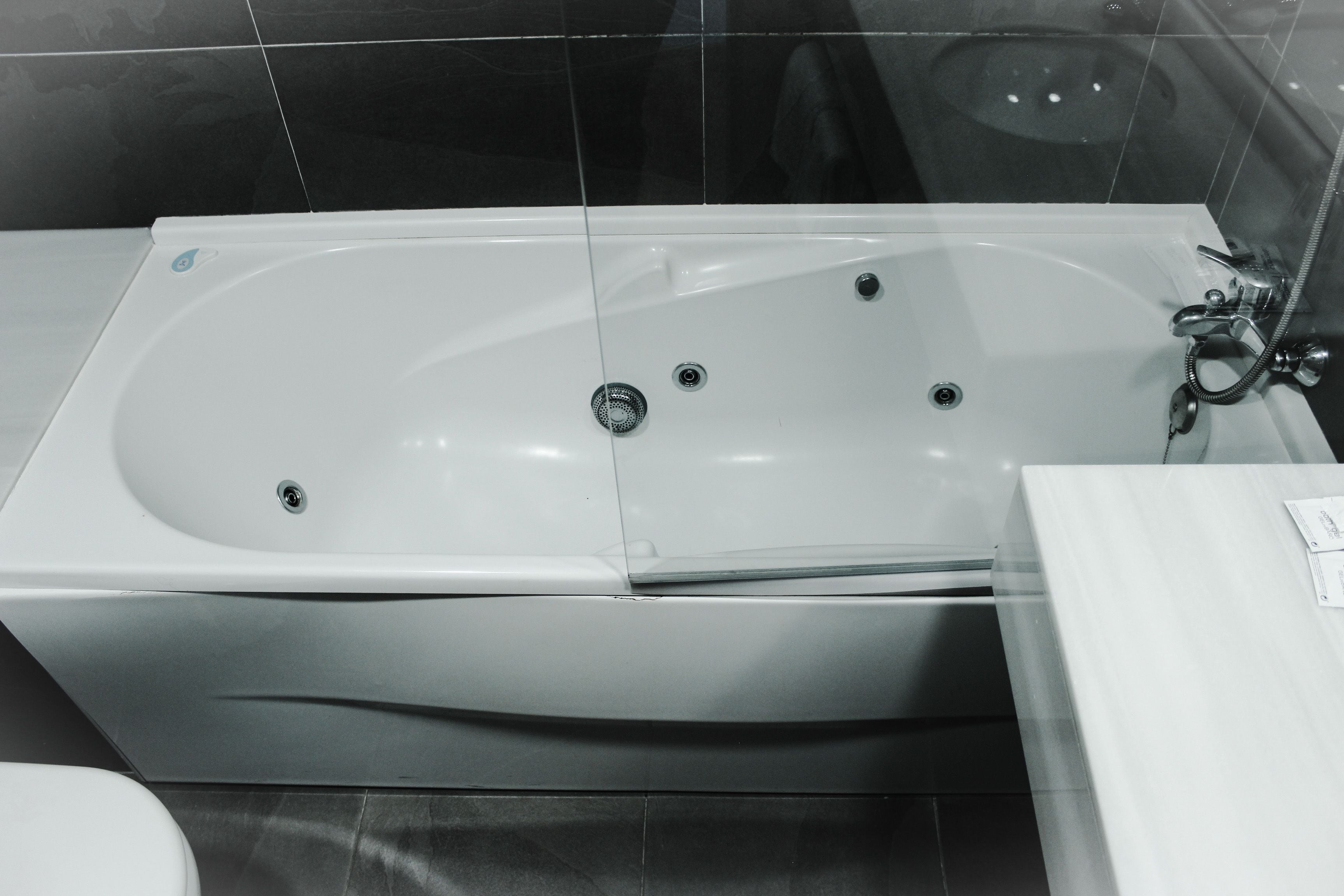 Une salle de bain moderne avec une grande baignoire, des toilettes et un lavabo.