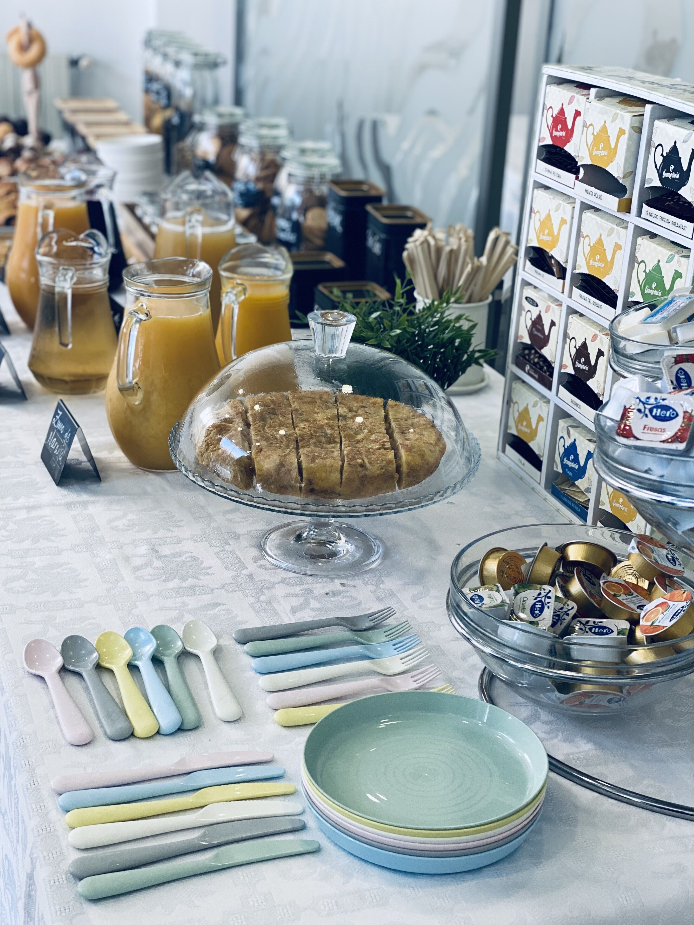 A breakfast buffet with various food items, including pastries, fruits, and beverages.