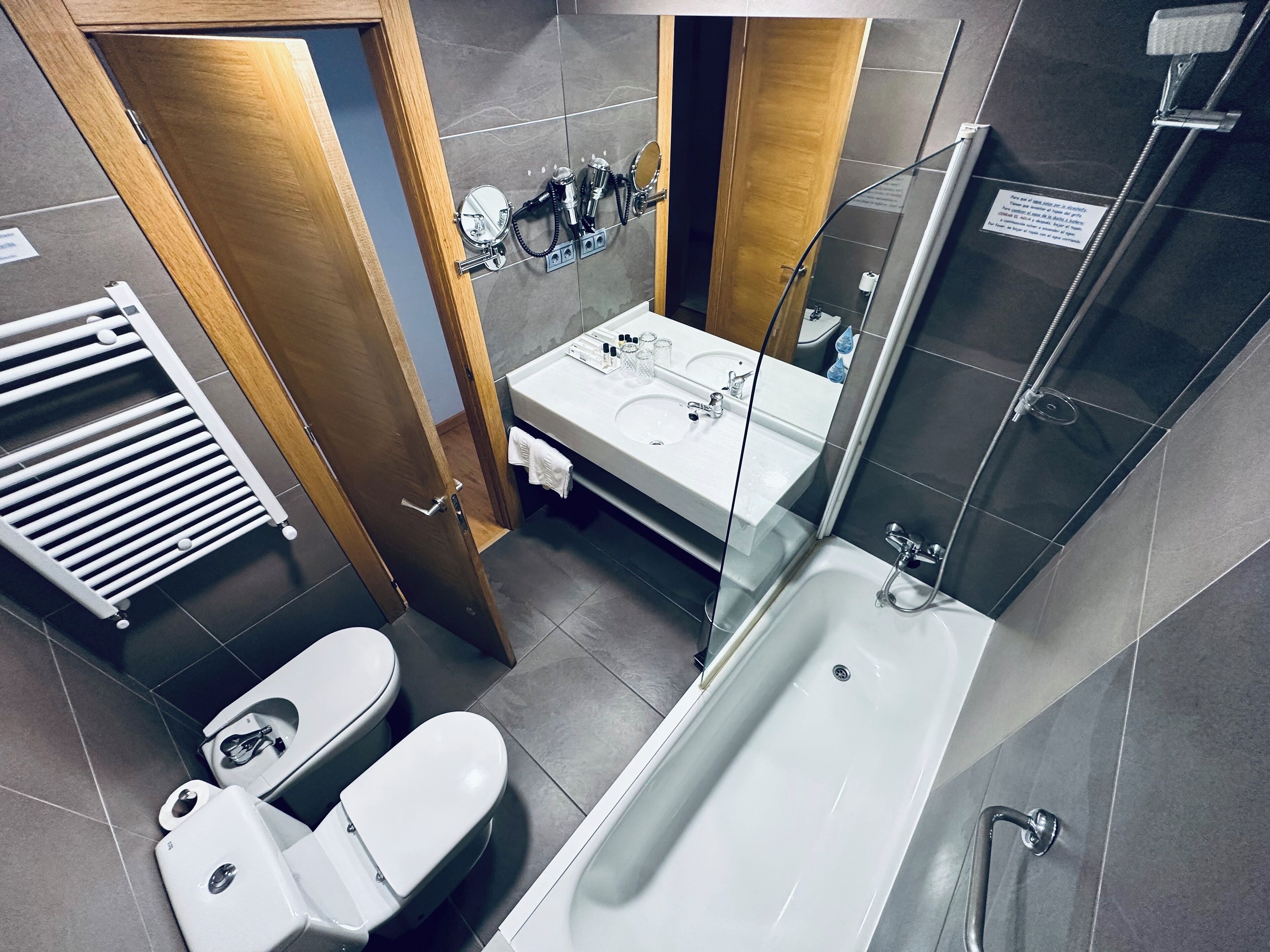 A modern bathroom with a bathtub, toilet, and sink.