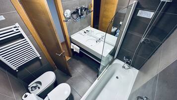 A modern bathroom with a bathtub, toilet, and sink.