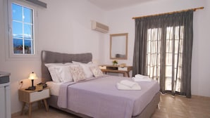 Une chambre à coucher avec un lit, une table de chevet, une lampe et une fenêtre avec des rideaux.