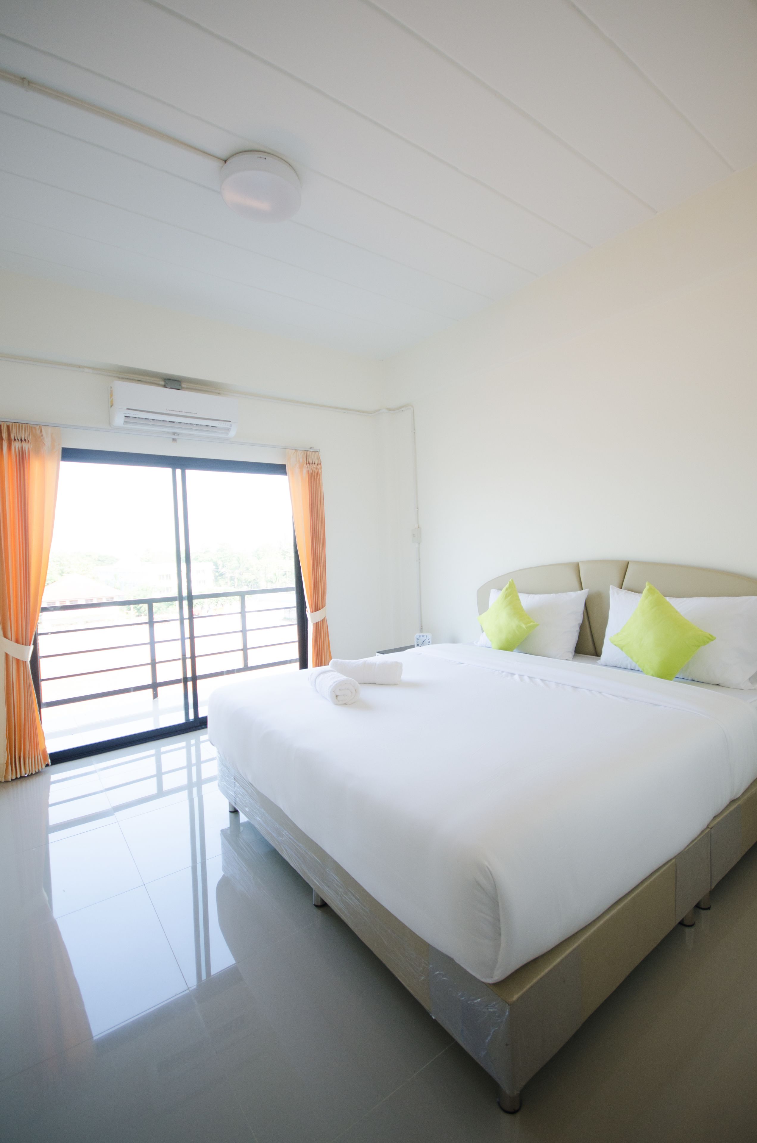 A hotel room with a large bed, a balcony, and a view of the outdoors.