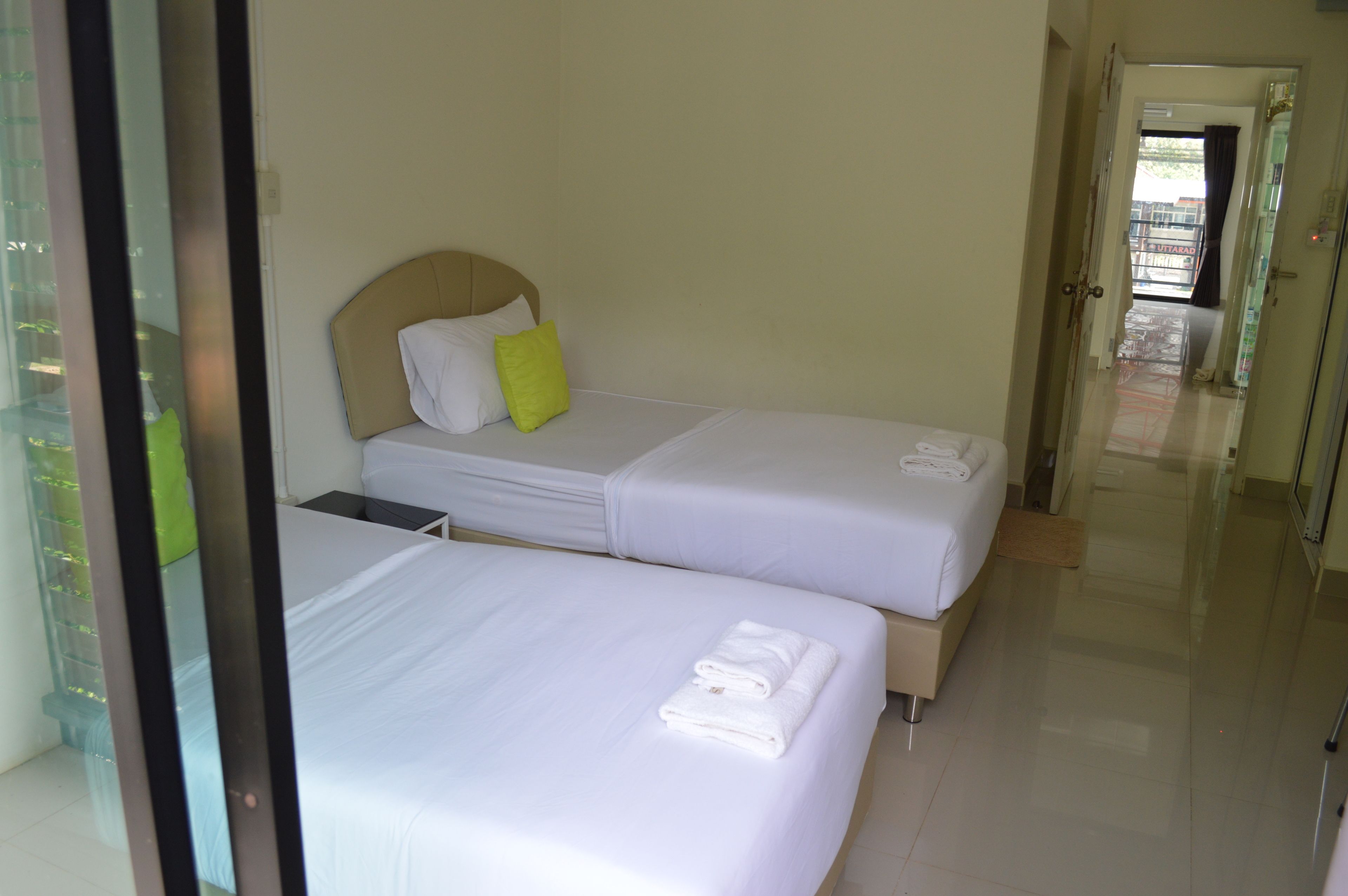 A hotel room with two beds, each with white linens and a pillow.