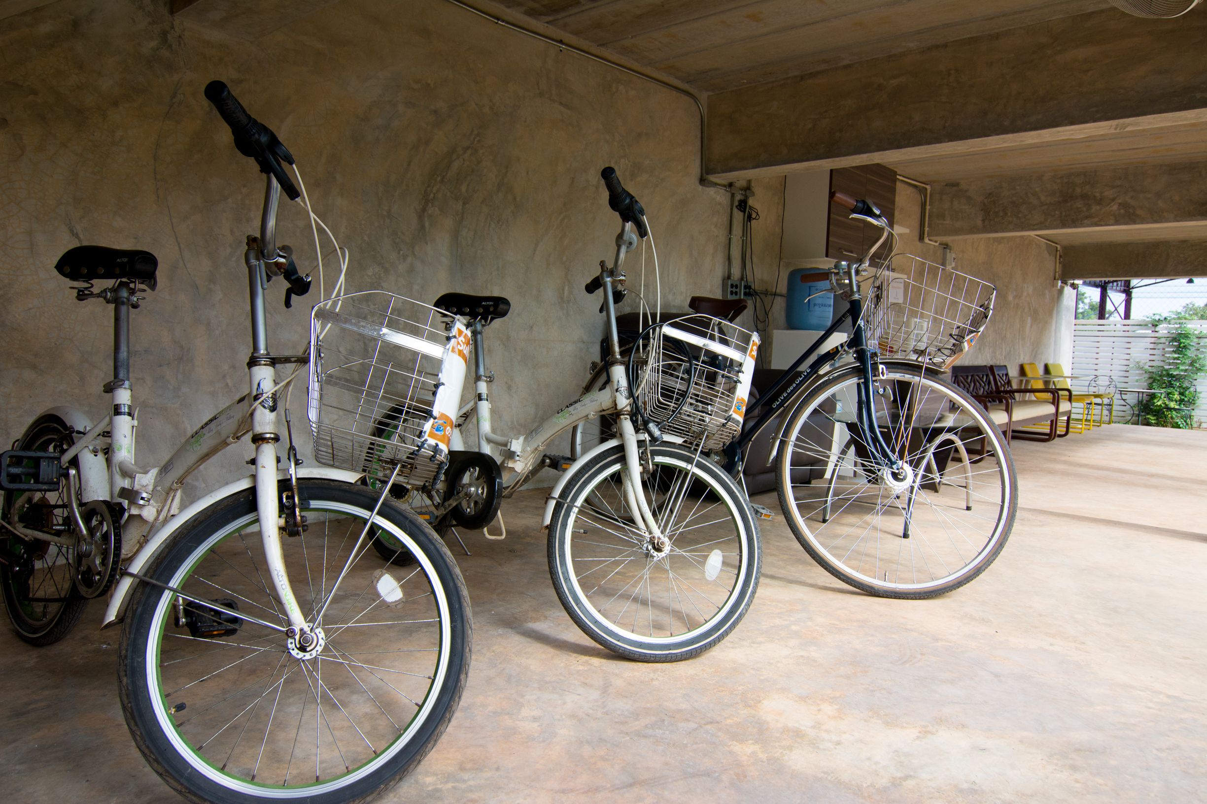 A covered parking area with bicycles parked against the wall.