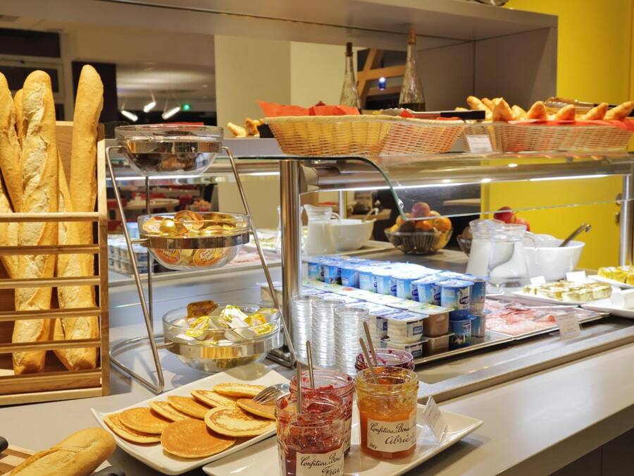 A buffet with various food items including bread, pastries, and condiments.