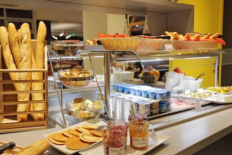 A buffet with various food items including bread, pastries, and condiments.