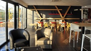 A modern interior with leather chairs, wooden tables, and large windows.