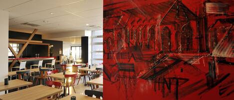 A modern dining area with wooden tables and chairs, a large red abstract painting on the wall, and a staircase leading to an upper level.