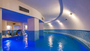 An indoor swimming pool with blue tiles and a curved ceiling. - Hotel Palace (Prajila)