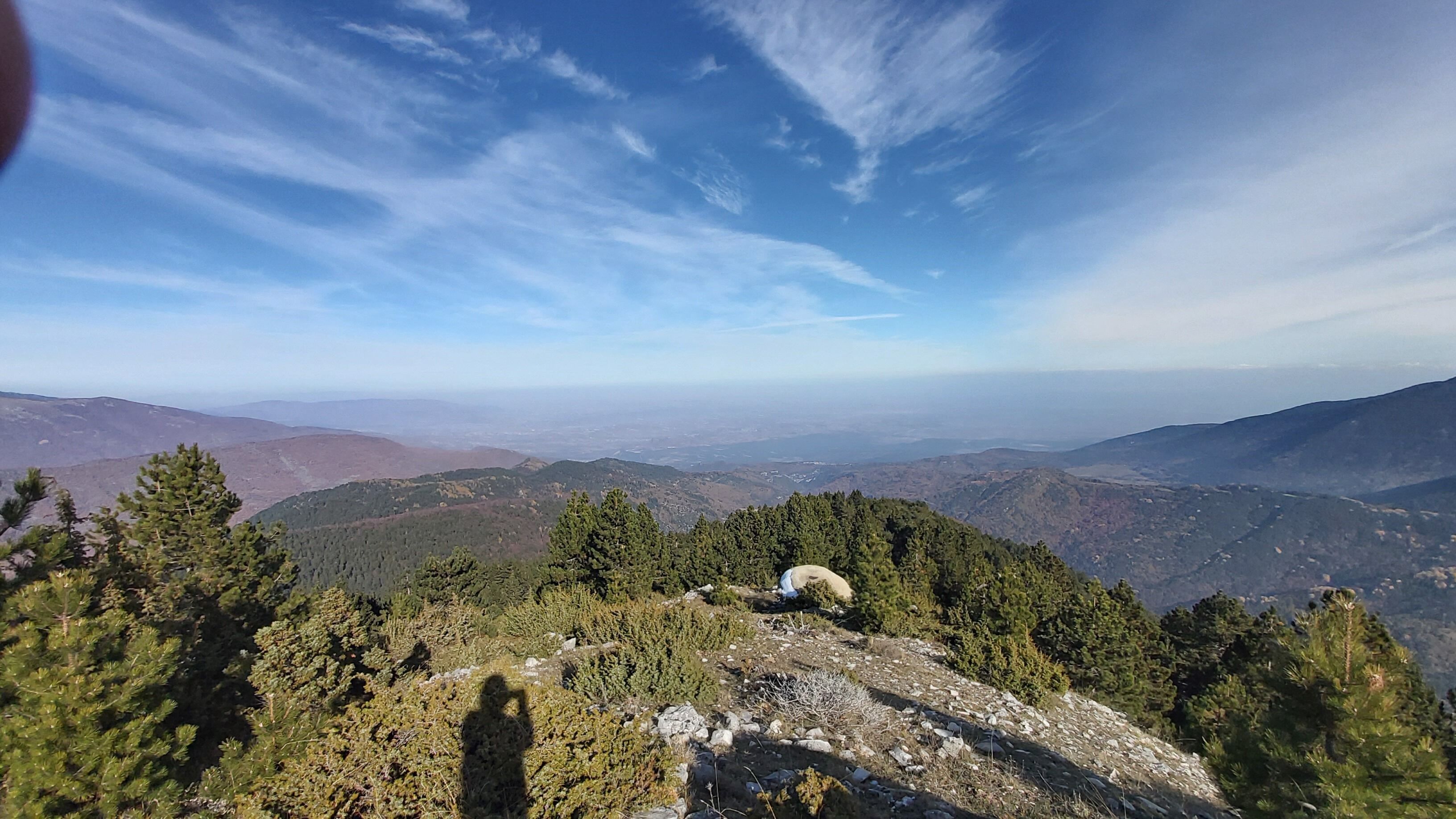 Un paisaje montañoso con bosques frondosos y cielo despejado.