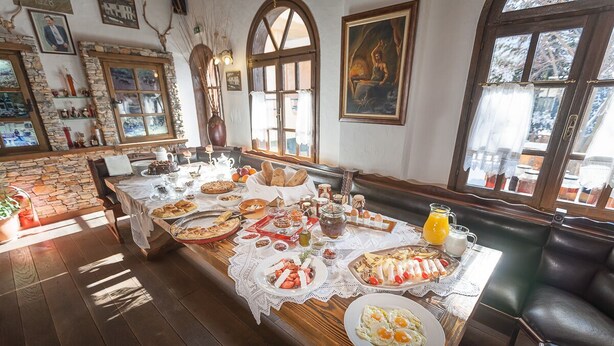 Un buffet de petit-déjeuner proposant une variété de plats, un coin café et un espace détente avec des fauteuils en cuir.