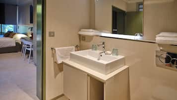 Un baño moderno con un lavamanos grande, un espejo y un perchero para toallas.