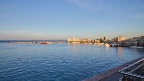 A waterfront cityscape with buildings along the shore and a calm sea. - Amalia Rooms (Chios)
