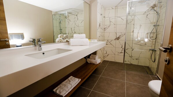 A modern bathroom with a large sink, mirror, and a glass-enclosed shower. - Fortezza Beach Resort (Marmaris)