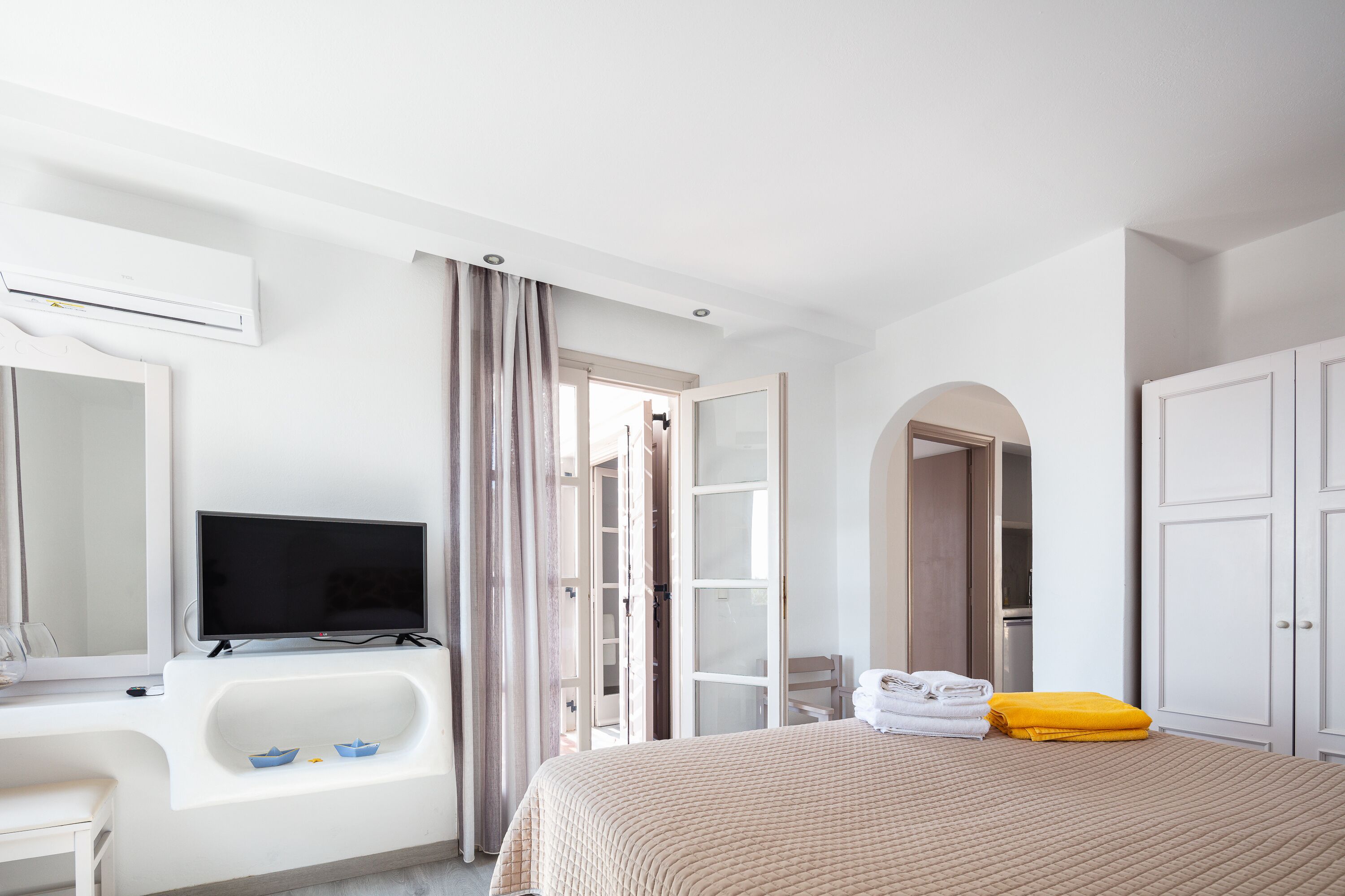 Une chambre d’hôtel équipée d’un lit, d’une télévision, d’un bureau, d’une baignoire et d’une armoire.