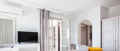 Une chambre d’hôtel équipée d’un lit, d’une télévision, d’un bureau, d’une baignoire et d’une armoire.