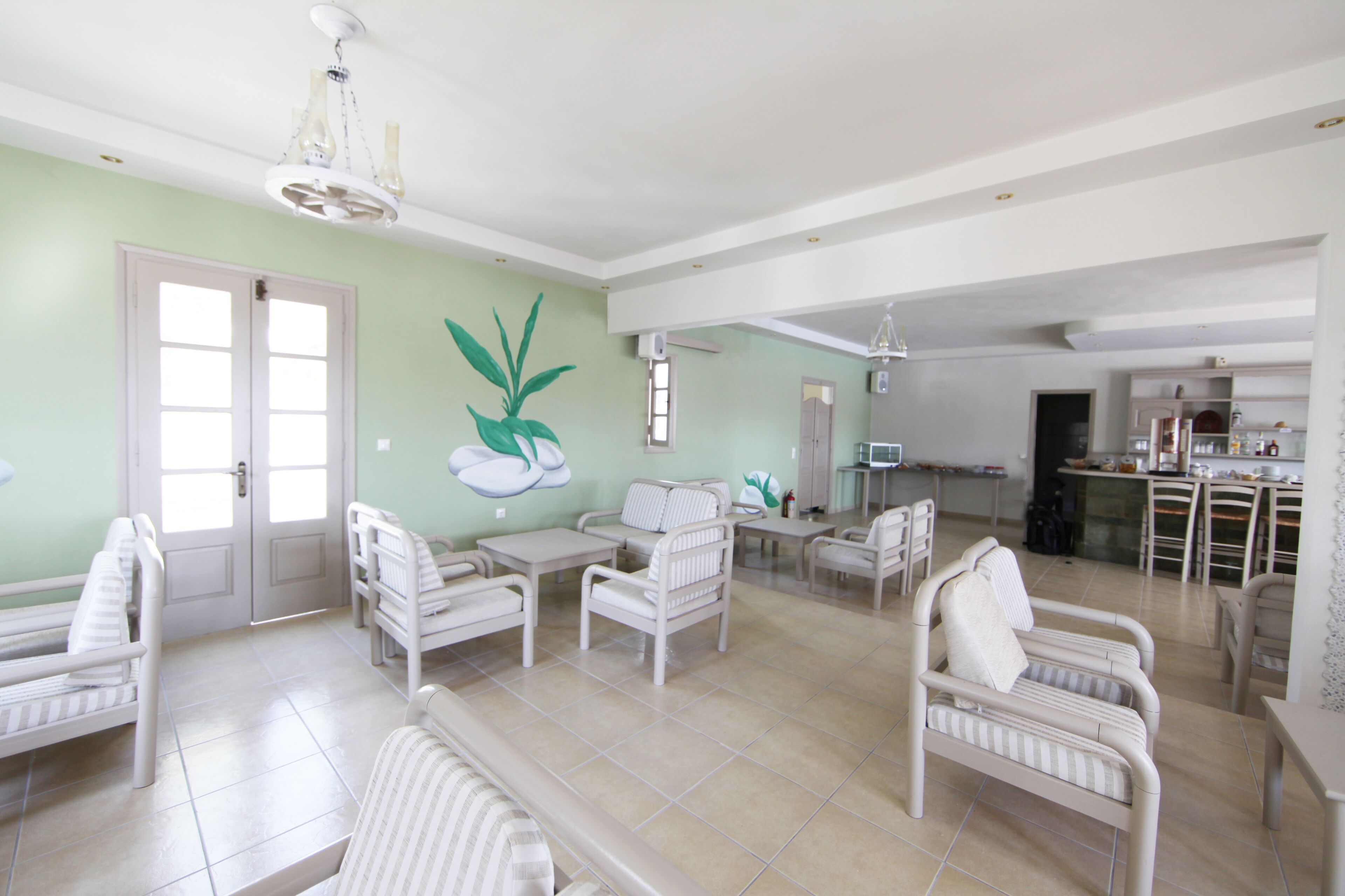A spacious living area with multiple seating options, a kitchen in the background, and a dining area.
