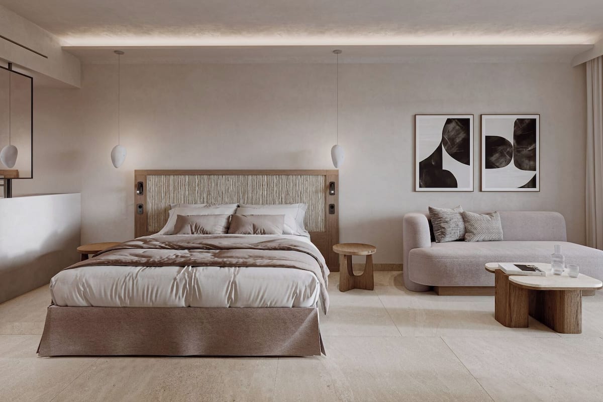 Ein modernes Schlafzimmer mit einem großen Bett, einer Couch, einem Couchtisch und zwei an der Wand befestigten Kunstwerken.