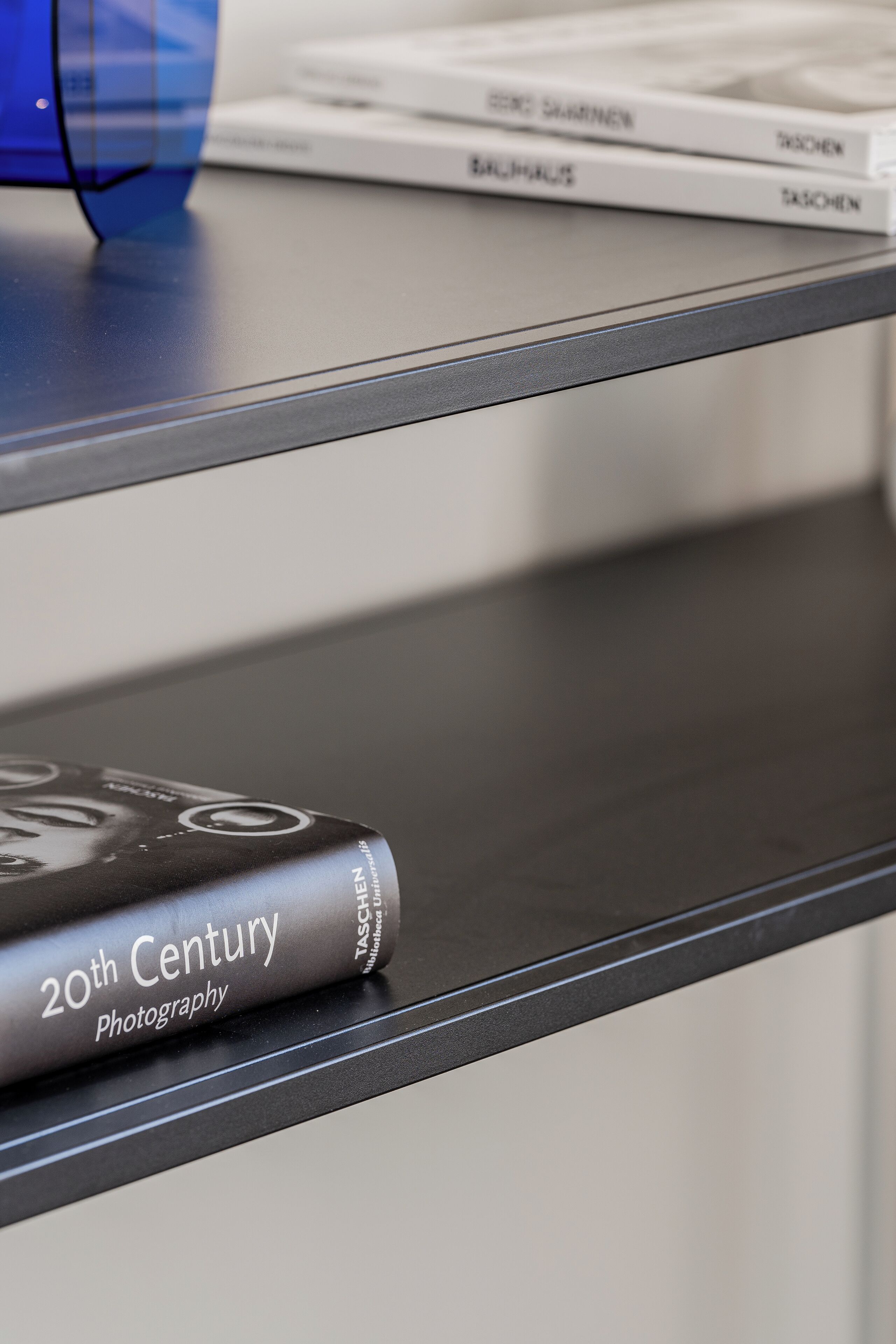 A book titled '20th Century Photography' on a shelf.