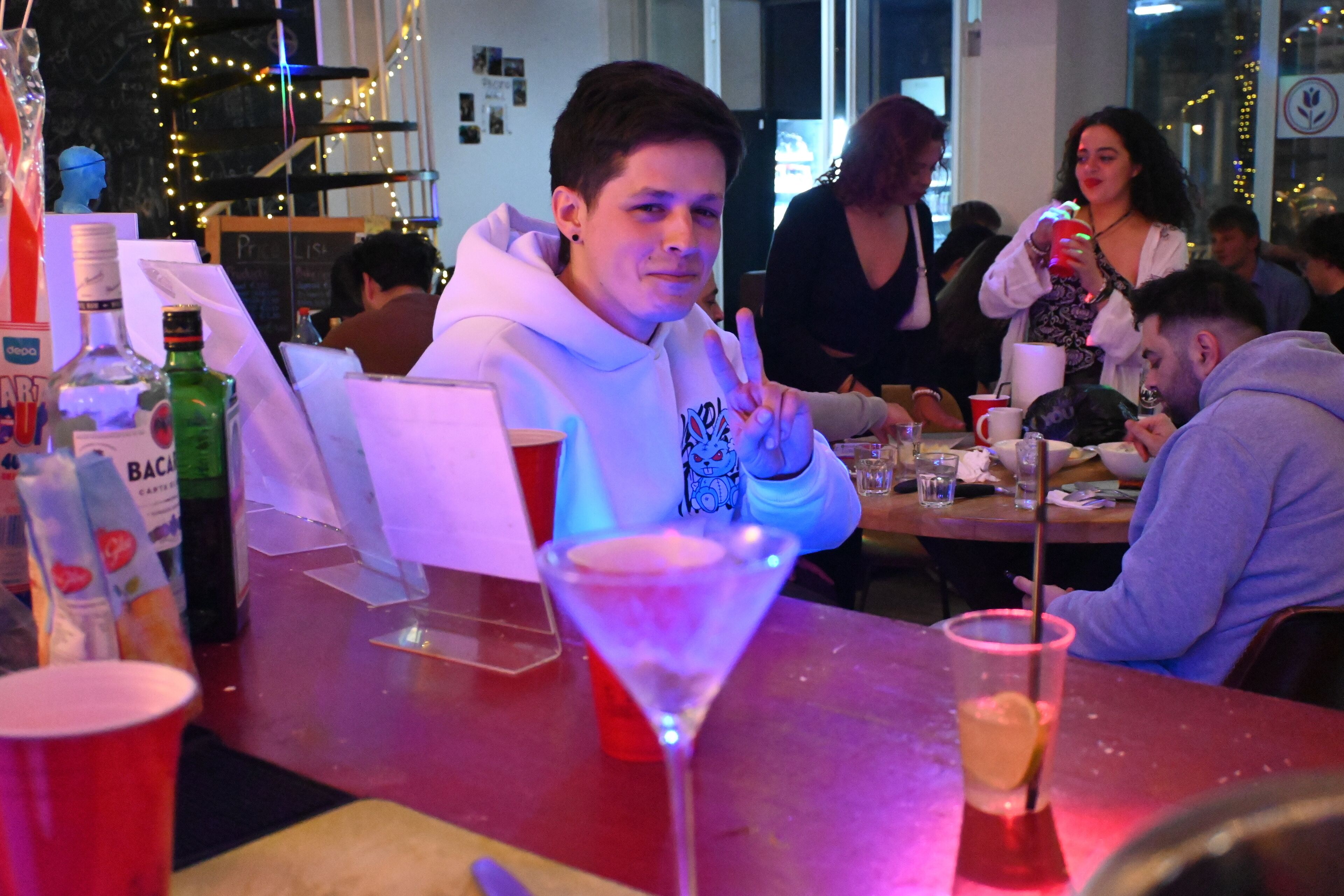 A bar area with a martini glass, bottles, and a red cup on the counter.