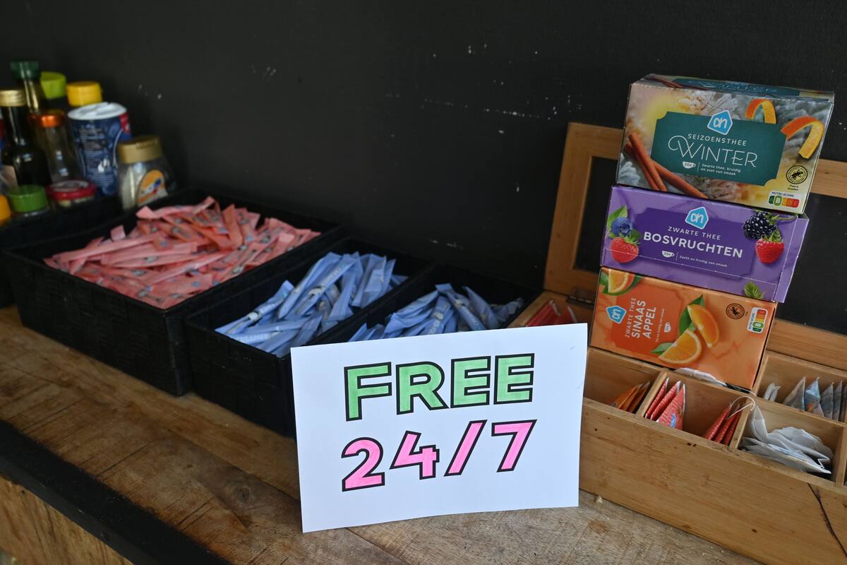 Una exhibición de diversos alimentos envasados, incluyendo un cartel que indica un servicio gratuito disponible las 24 horas del día, los 7 días de la semana.