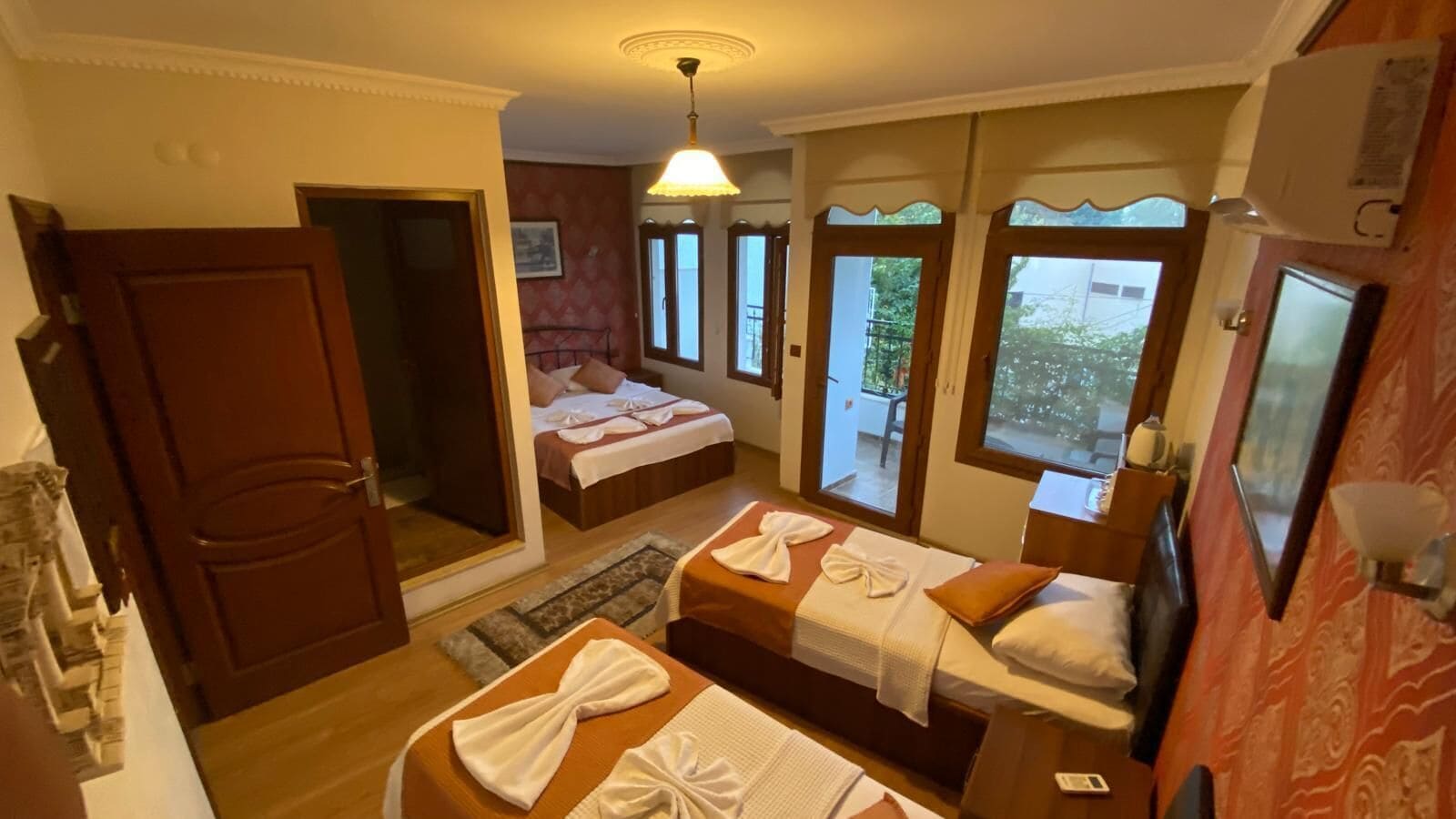 Ein Hotelzimmer mit zwei Betten, einer Sitzecke und Blick ins Freie.