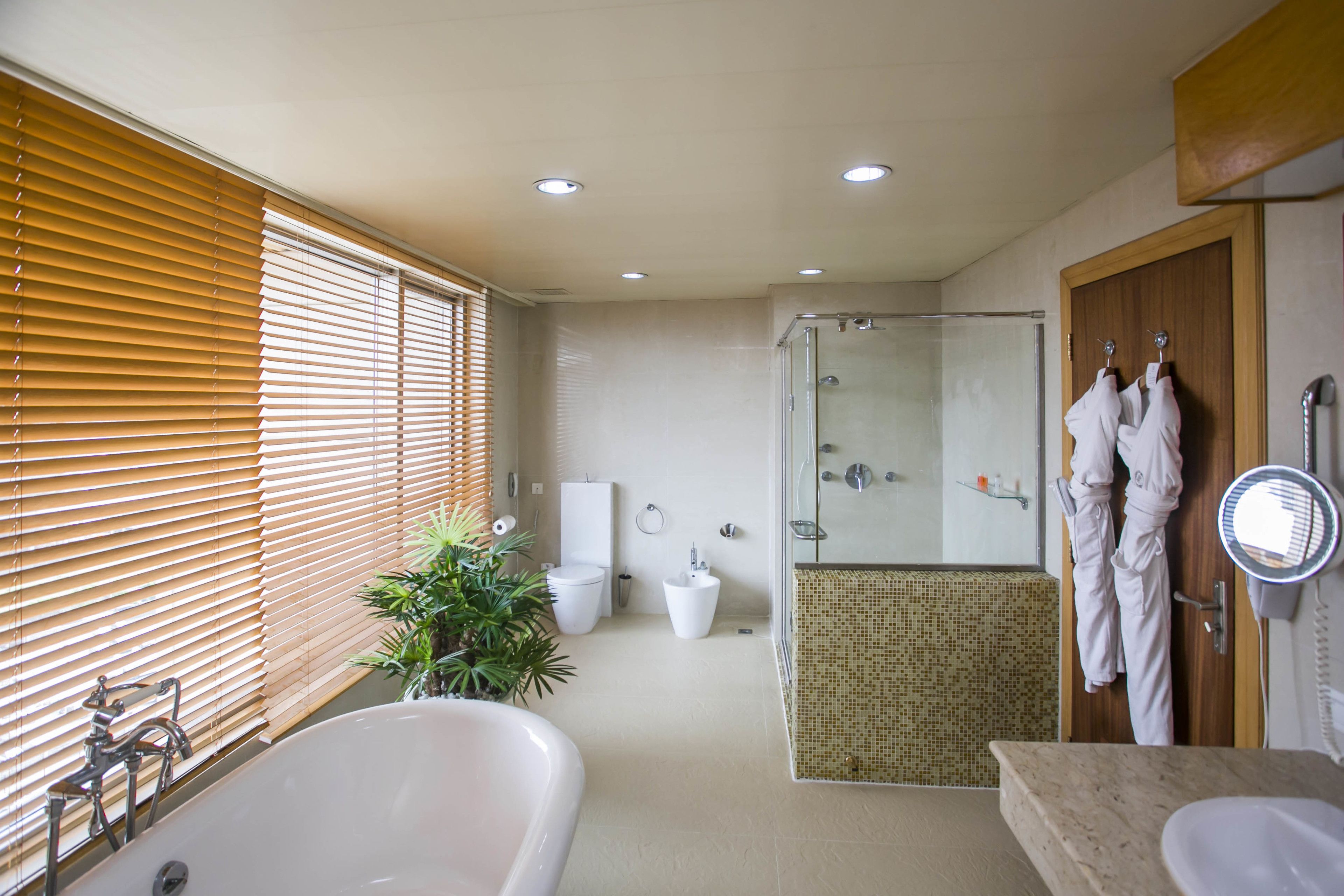 A modern bathroom with a bathtub, sink, and shower area.