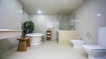 A modern bathroom with a bathtub, a glass-enclosed shower, a sink, and a toilet.