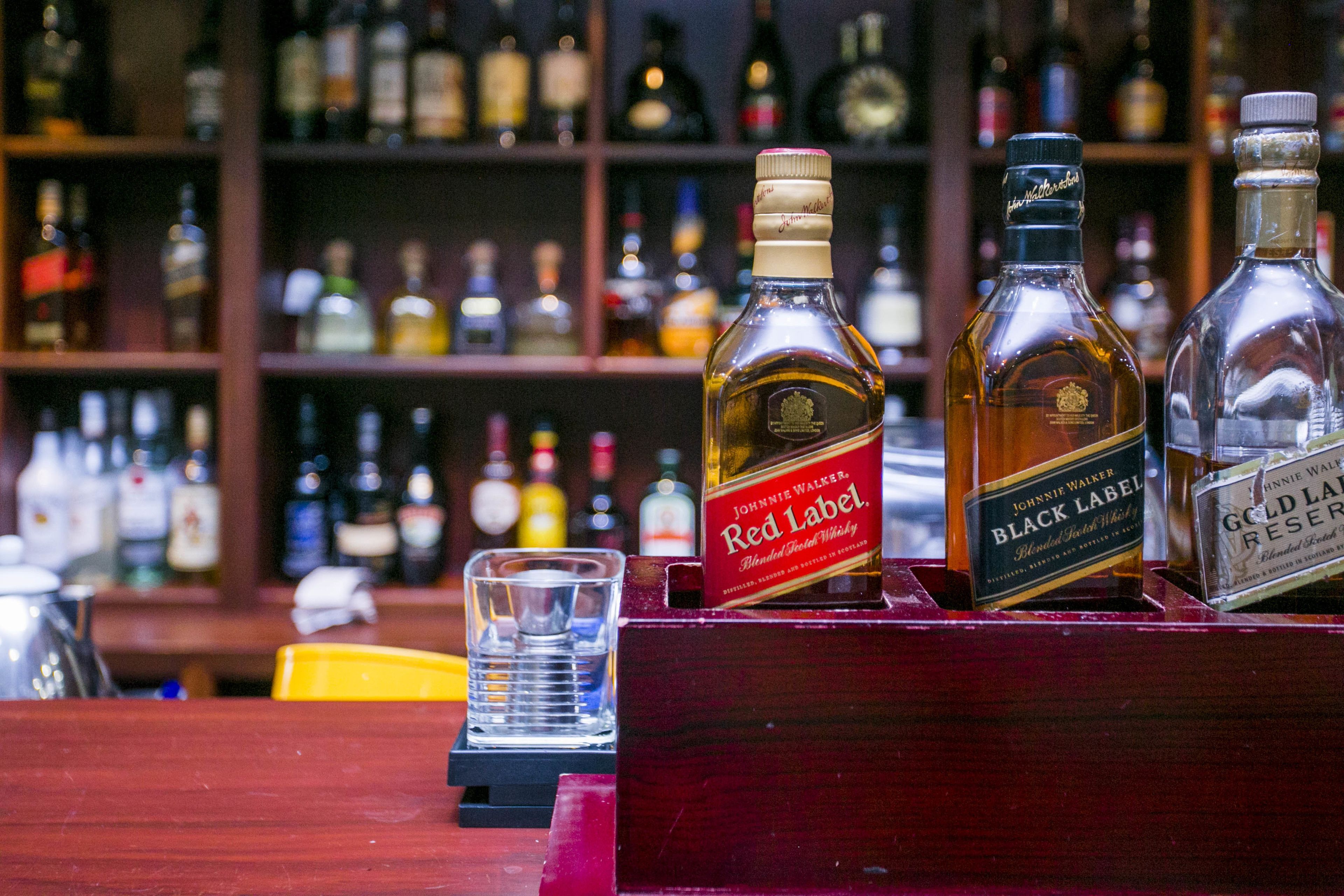 A bar with bottles of Johnnie Walker Red Label, Black Label, and Gold Label Reserve whisky.