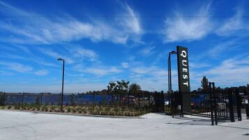 A parking lot with a fence and a sign that reads "QUEST".