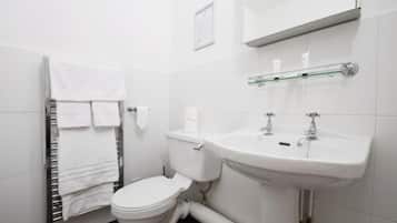 A modern bathroom with a toilet, sink, and towel rack.