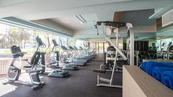 Un gimnasio con cintas de correr, elípticas y máquinas de pesas.