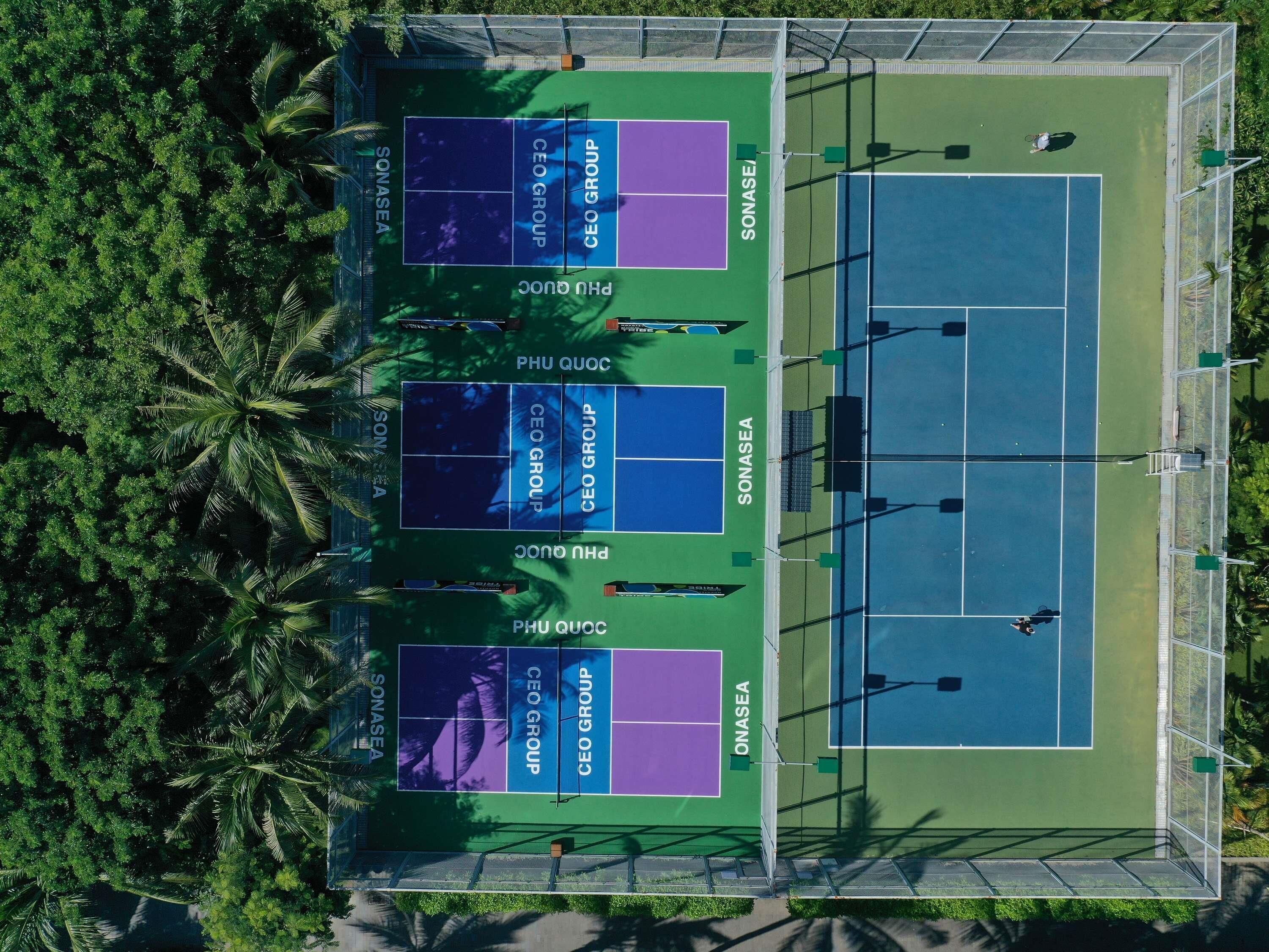 Pistas de tenis múltiples, rodeadas de follaje.