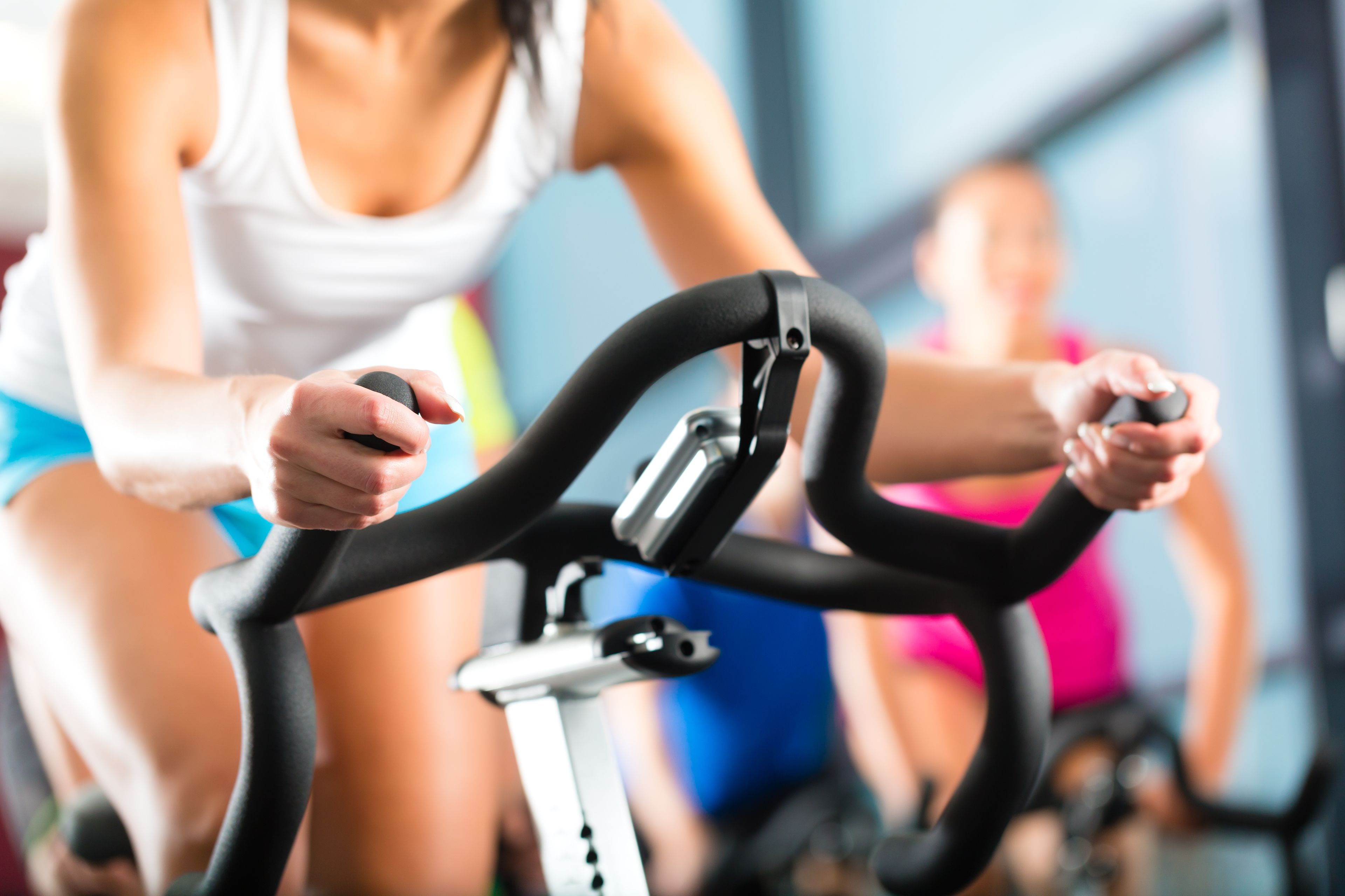 Una persona pedaleando en una bicicleta estática en un gimnasio.