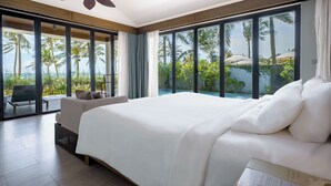 A spacious bedroom with a large bed, a ceiling fan, and a view of palm trees and a pool. - Novotel Phu Quoc Resort (Phu Quoc)