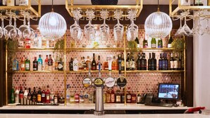 A bar area with a variety of liquor bottles, a tap system, and hanging wine glasses. - Shaw Hill Golf Resort & Spa Hotel (Chorley)