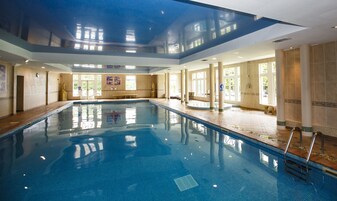Una piscina techada, sillones reclinables de piscina