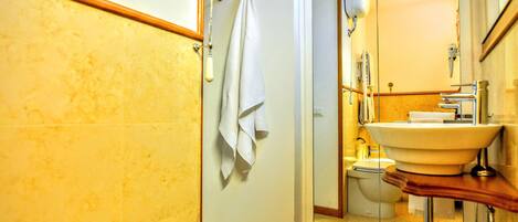 A bathroom with a bathtub, a sink, a toilet, and a mirror.