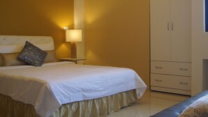 A bedroom with a bed, bedside lamps, a wardrobe, and a chandelier. - Riverstupid B&B (Hengchun)
