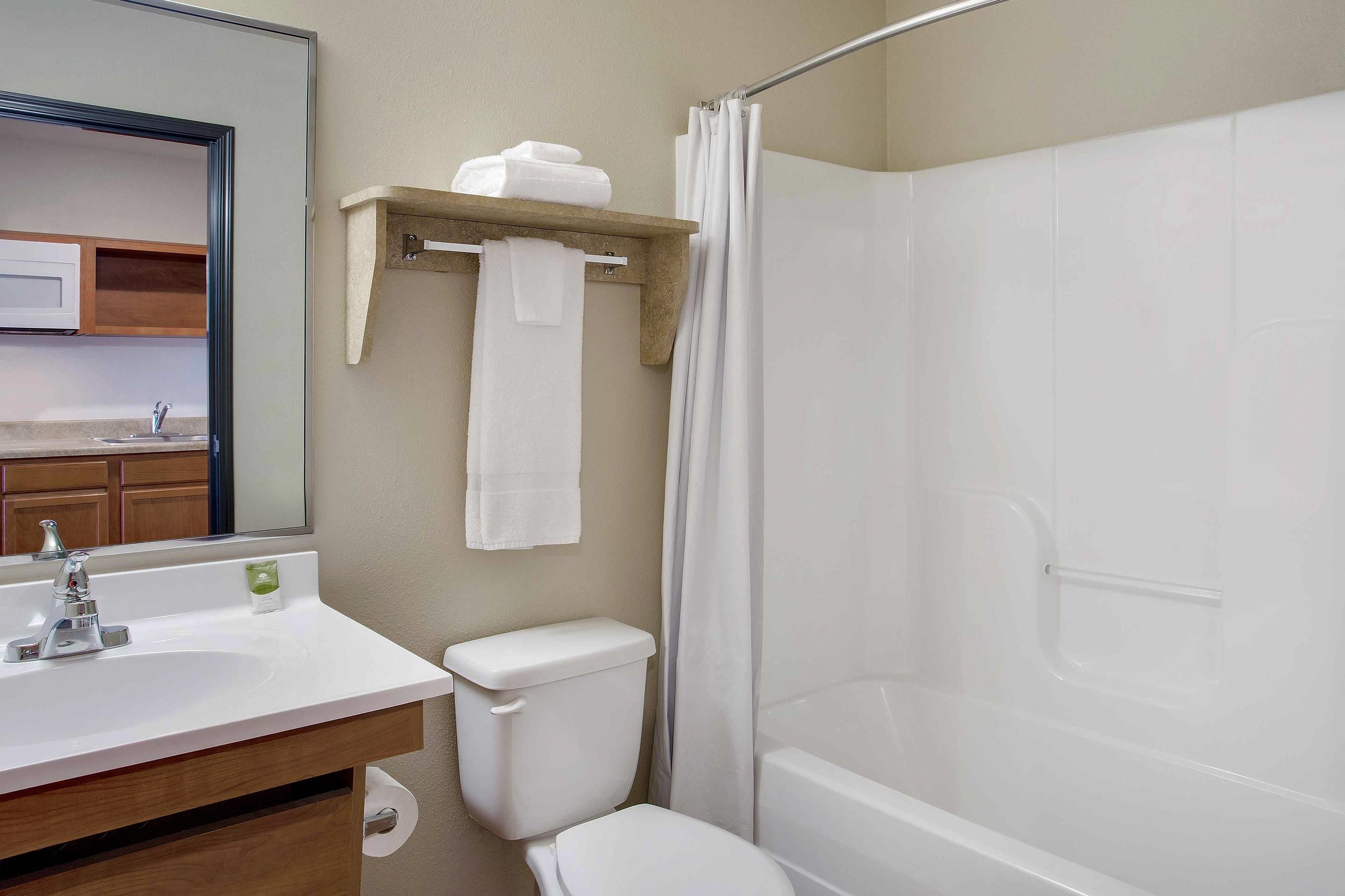A bathroom with a white sink, toilet, and bathtub. There is a towel rack with a towel hanging on it.