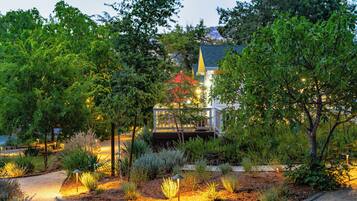 A landscaped garden with a gazebo, surrounded by various plants and trees.